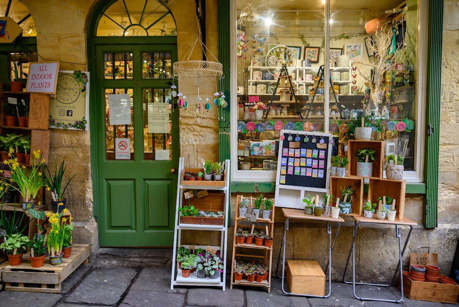 Exterior view of Harold Wood Florist shop on High Street, featuring a green wooden door with signage indicating indoor plants, and a large display window showcasing various floral arrangements and dec
